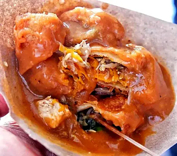 Lumpia khas Klungkung dipotong dan disiram saus khas